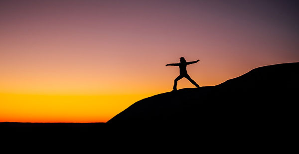 woman exercising on hill at sunset